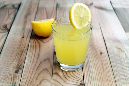 Glass of lemonade on wood background
