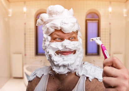 Adult man with shaving foam on his face is going to shave his head